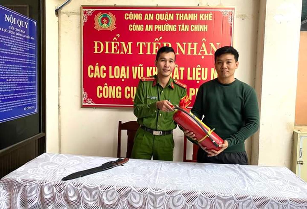 Công an phường Tân Chính thu nhận hung khí và trao tặng bình chữa cháy xách tay cho người dân.