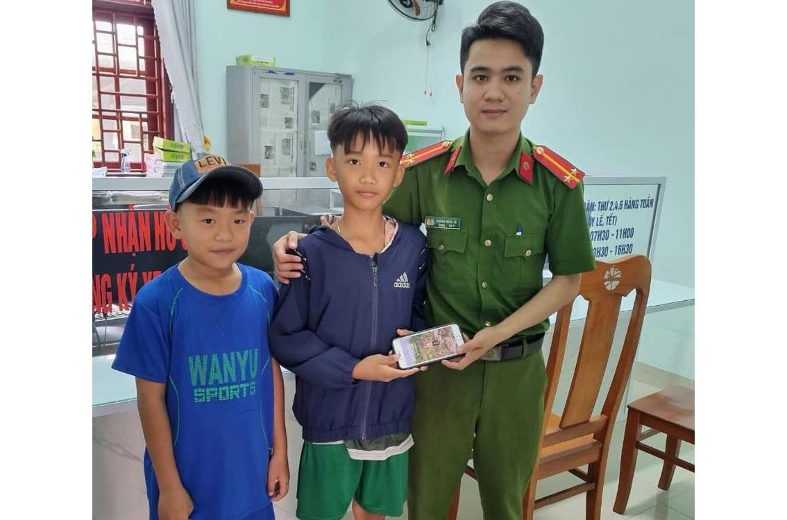 Em Công và em Quốc mang chiếc ĐTDĐ nhặt được đến giao nộp cho Công an.