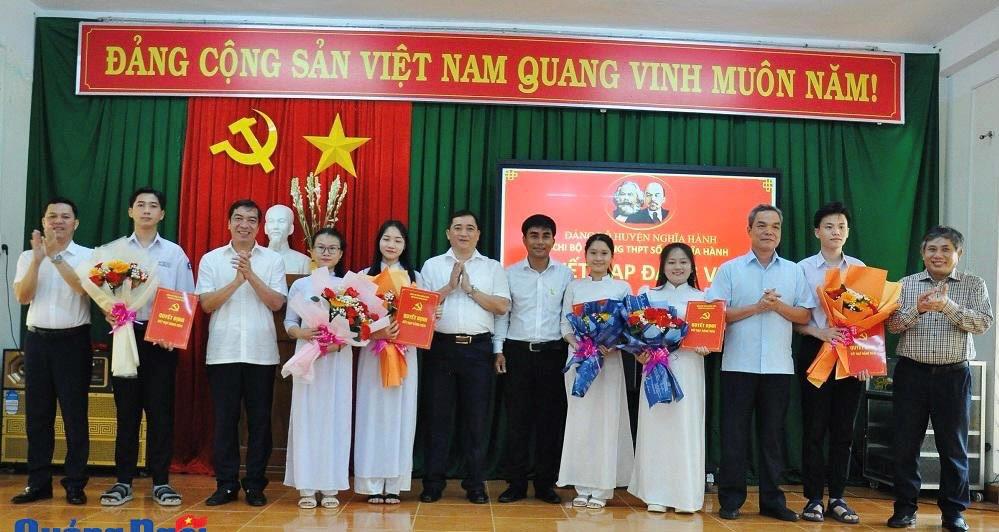 Trưởng ban Tổ chức Tỉnh ủy (ngoài cùng bên phải), Trưởng ban Tuyên giáo Tỉnh ủy (thứ 10 từ trái qua) và lãnh đạo huyện Nghĩa Hành, nhà trường trao quyết định, tặng hoa chúc mừng các đảng viên mới.