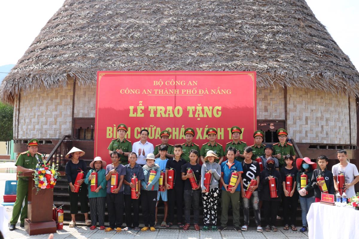 Lãnh đạo Phòng Cảnh sát PCCC và CNCH cùng Công an huyện Hòa Vang tặng bình chữa cháy xách tay cho các hộ dân là người đồng bào dân tộc thiểu số tại xã Hòa Phú.