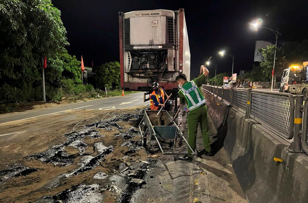 Cán bộ Công an xã Quảng Xuân cùng người dân dùng cát xử lý vệt dầu loang.