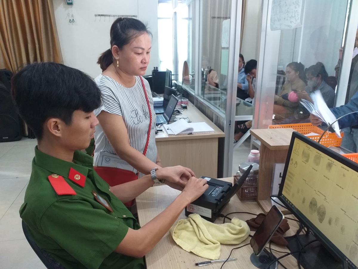 Cán bộ Đội CSQLHC về TTXH Công an quận Thanh Khê lấy vân tay cho công dân.