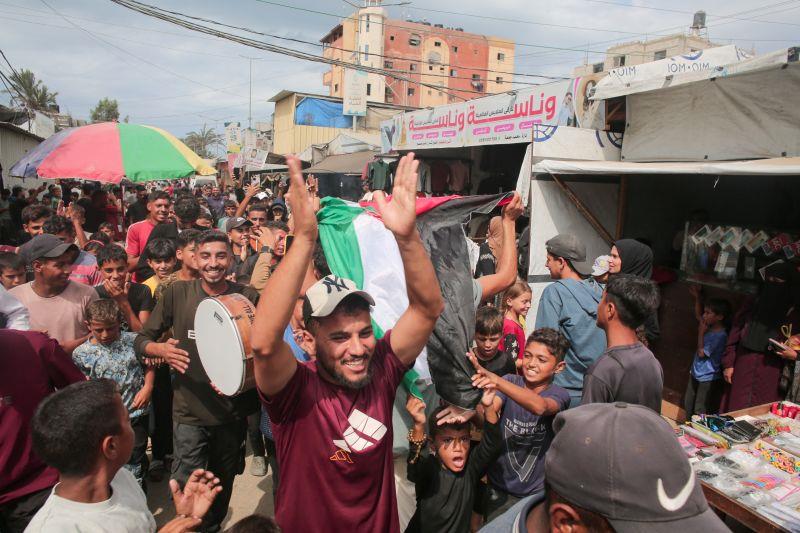 Người dân Palestine ở Dải Gaza ăn mừng tin tức về thỏa thuận ngừng bắn hôm 9-10. Ảnh: AFP