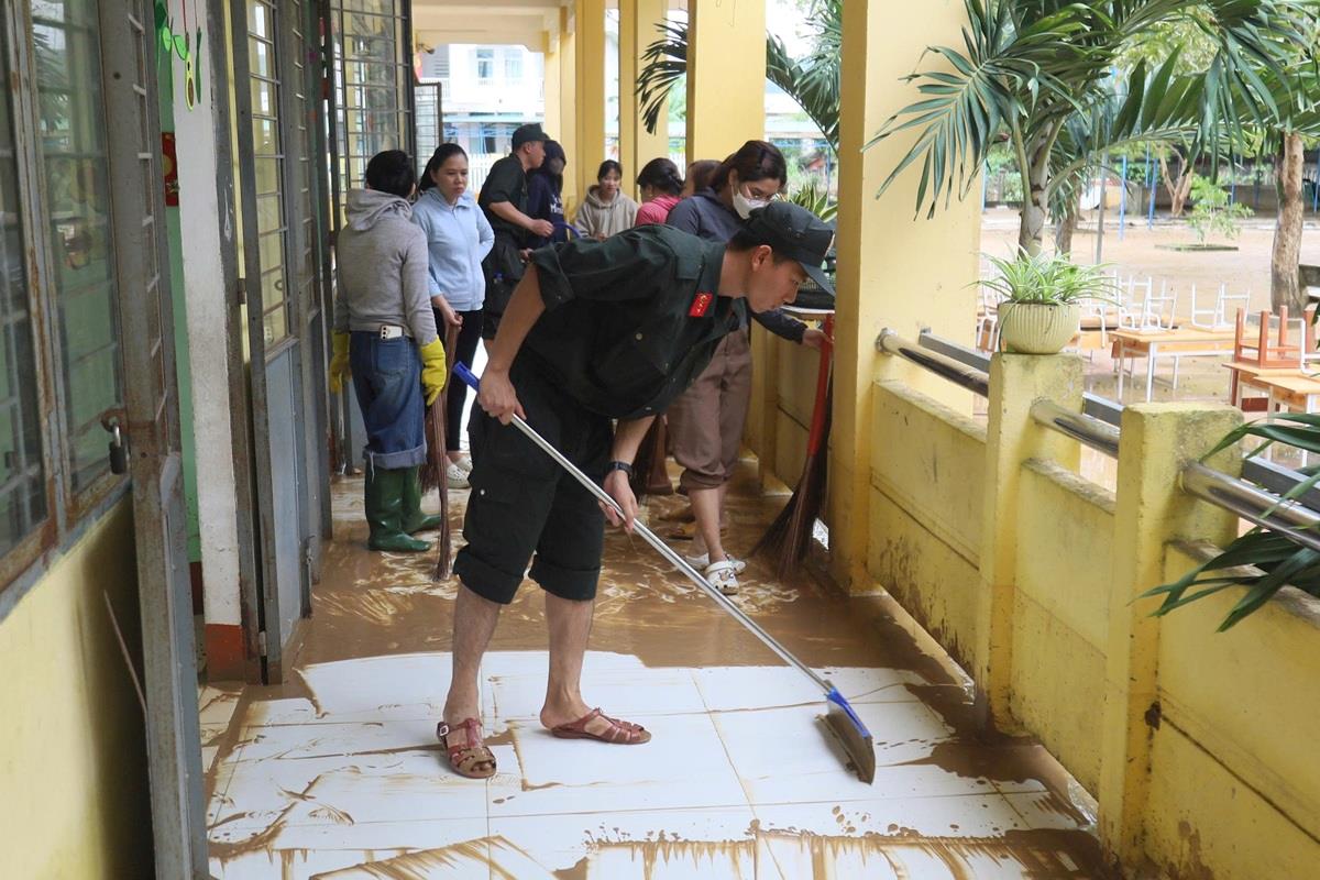 Cảnh sát cơ động hỗ trợ dọn dẹp nhà dân sau khi lũ rút