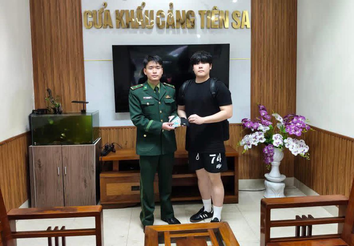 Thuyền viên Kim (bên phải) nhận lại tài sản do BĐBP tìm được.