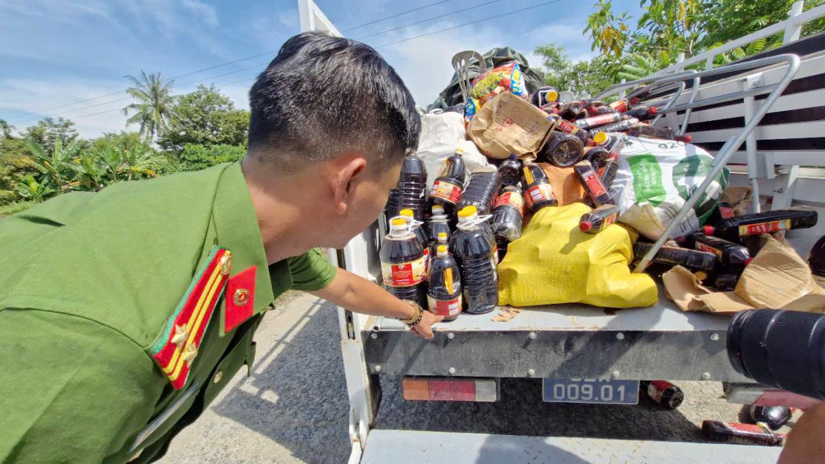 Lực lượng Công an cùng người dân thu gom số nước mắm bị vứt bỏ đưa về trụ sở xã để kiểm đếm.