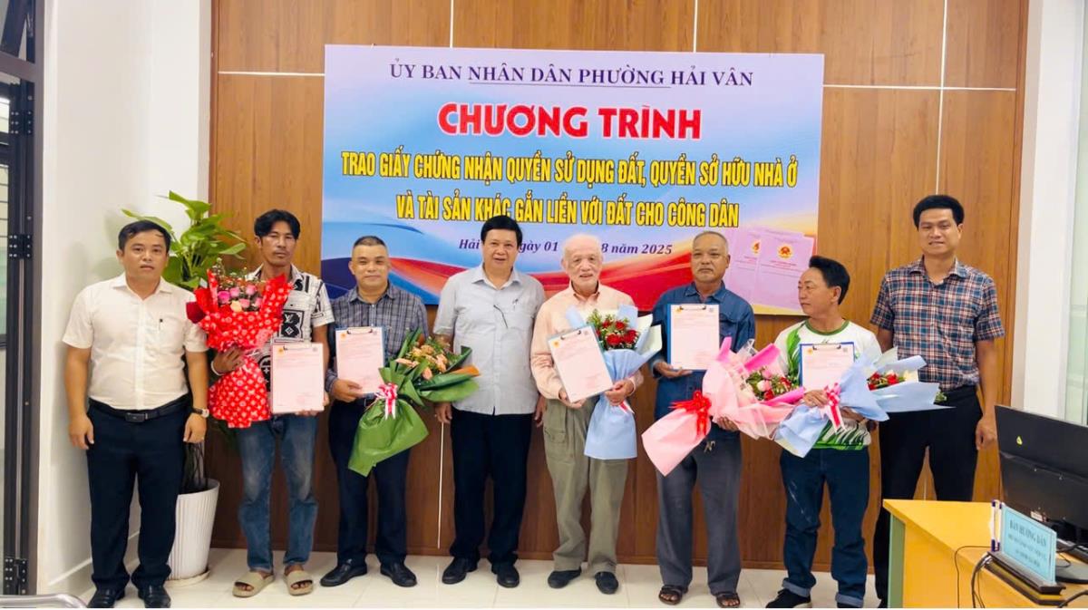 Chủ tịch UBND phường Hải Vân Nguyễn Thúc Dũng trao sổ hồng và tặng hoa chúc mừng cho các công dân.