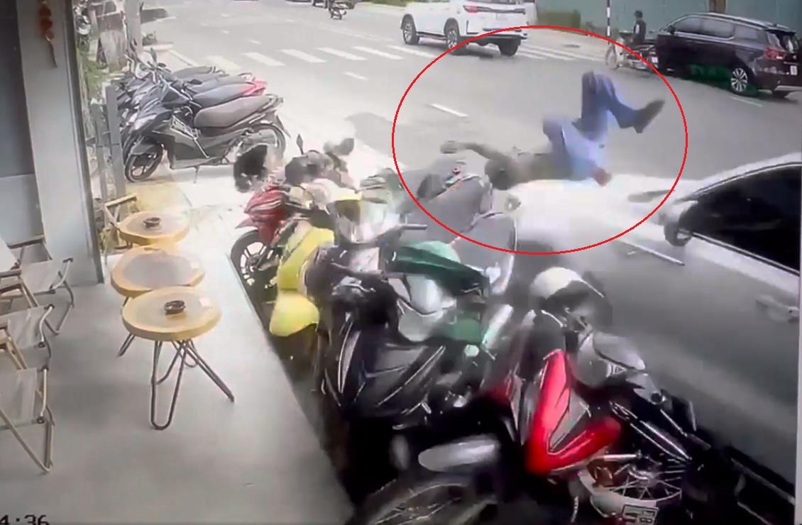 Hình ảnh chiếc ô-tô lao lên lề tông văng người đi đường và nhiều xe máy.