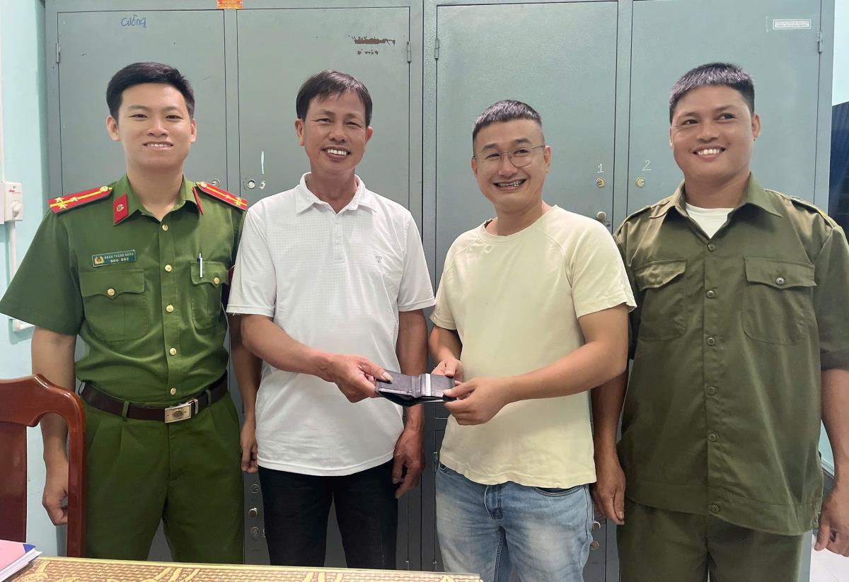 Anh Tâm trao lại tài sản nhặt được cho anh Công.