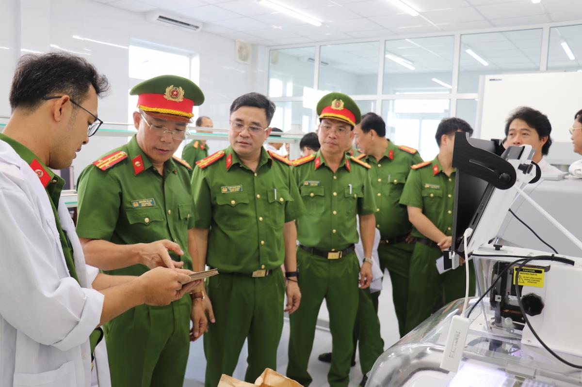 Đại tá Trịnh Tuấn Toàn, Đại tá Nguyễn Hà Lai cùng đại biểu tham quan phòng giám định ADN.