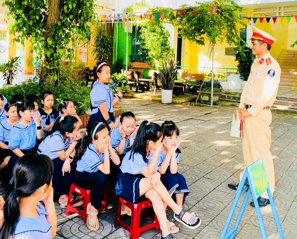 Cán bộ Trạm CSGT cửa ô Hòa Phước trang bị các kiến thức về ATGT cho các em học sinh.