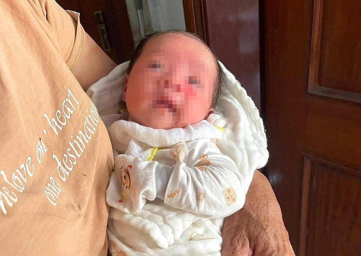 Bé gái bị bỏ rơi đang được một người dân chăm sóc.