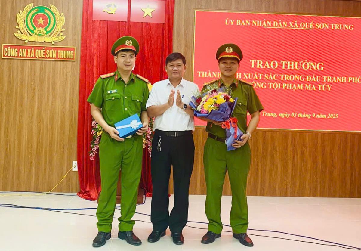 Chủ tịch UBND xã Quế Sơn Trung trao thưởng cho lực lượng Công an xã.