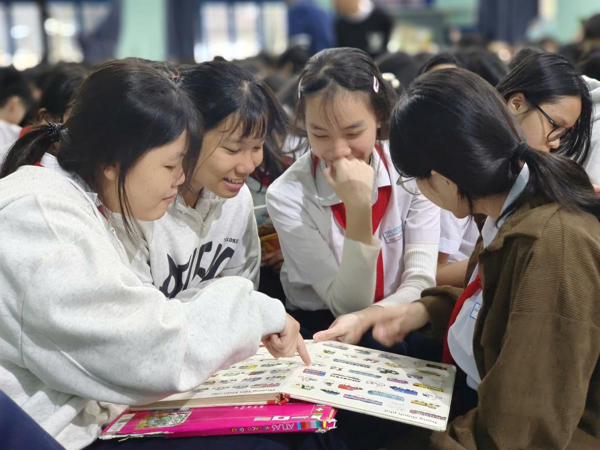 Các em HS thích thú với việc chọn sách và đọc sách tại xe thư viện lưu động.