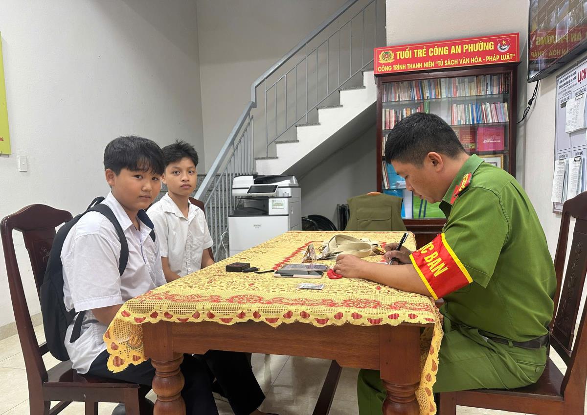 Hai em Chí Thiện và Thiên Phúc giao nộp tài sản nhặt được cho Công an phường.