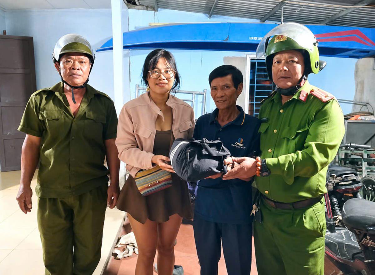 Hạ sĩ Trần Nhật Minh (đứng giữa) trao lại tài sản cho chị Quyên.