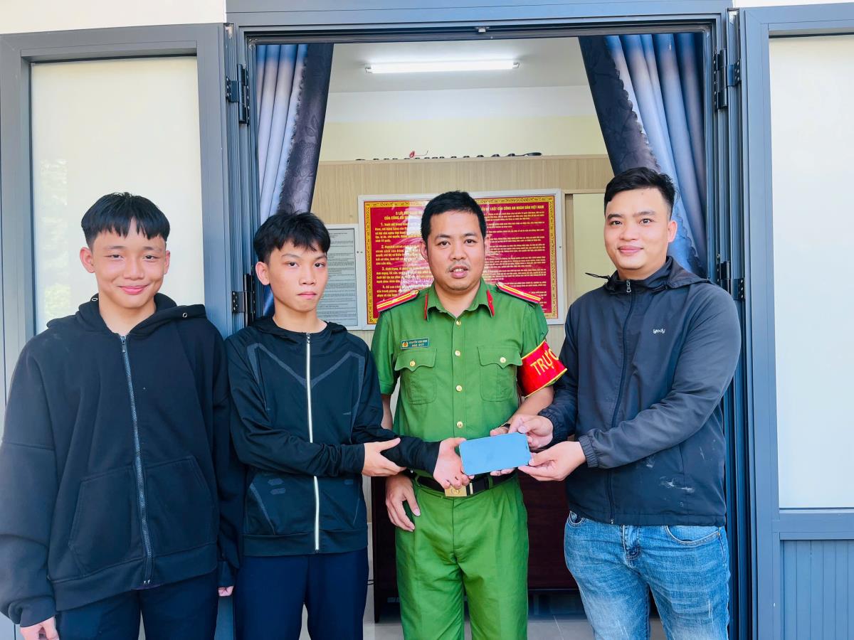 Hai nam sinh và Công an xã trao lại tài sản cho anh Phương (bìa phải).