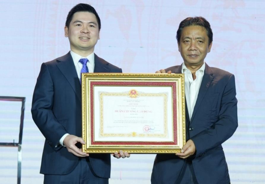Chủ tịch Hà Nội FC Đỗ Vinh Quang (trái) vinh dự đón nhận Huân chương Lao động hạng Nhì.