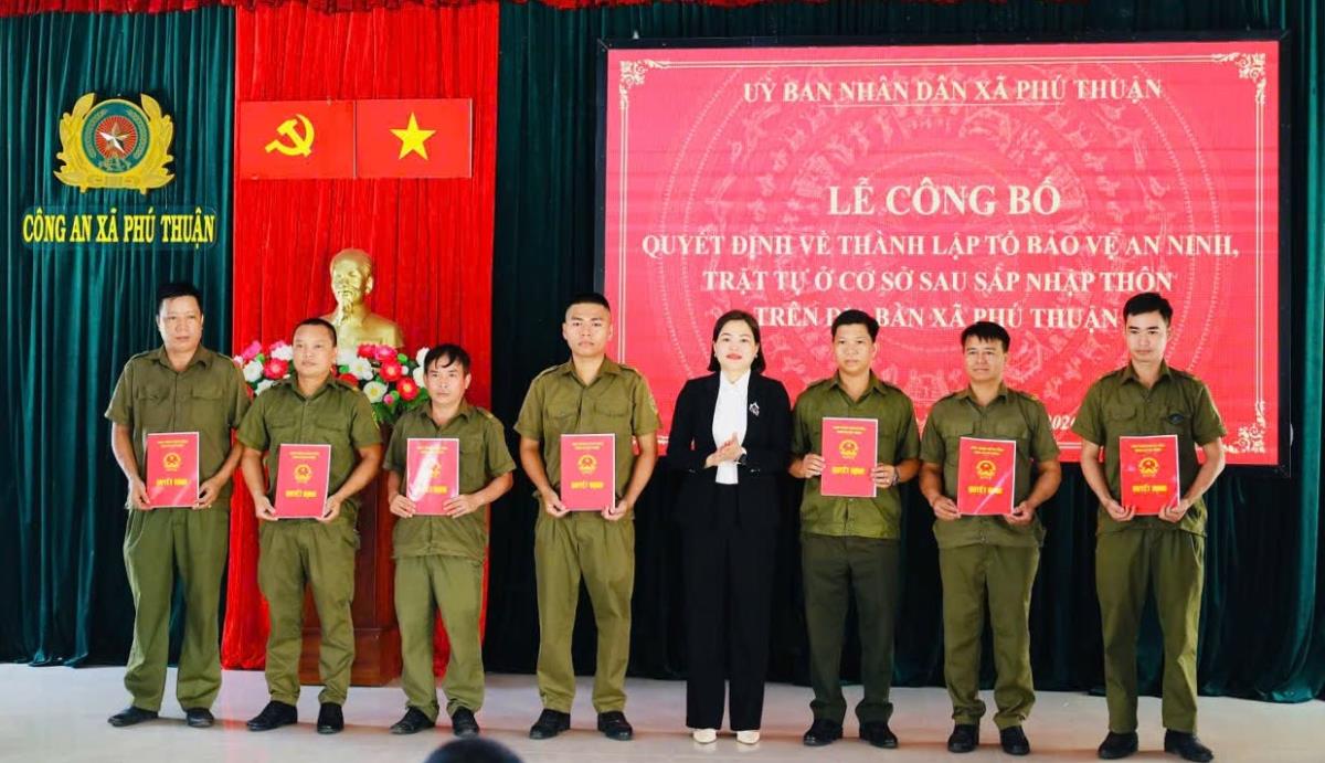 Chủ tịch UBND xã Nguyễn Thị Hồng, Thượng tá Trần Minh Quang - Trưởng Công an xã trao Quyết định thành lập mới 14 Tổ bảo vệ ANTT ở cơ sở tại 14 thôn.