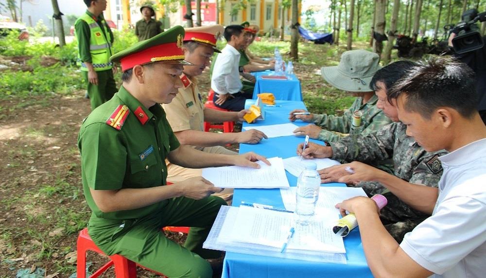 Công an xã Đắk Mil cho các chủ phương tiện ký cam kết chấp hành Luật Giao thông đường bộ.