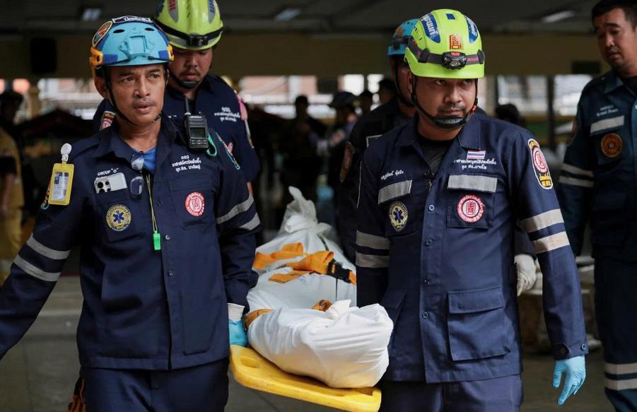 Nhân viên cứu hộ đưa thi thể nạn nhân đi sau vụ xả súng tại trường học hôm 7-8 - Ảnh: Reuters