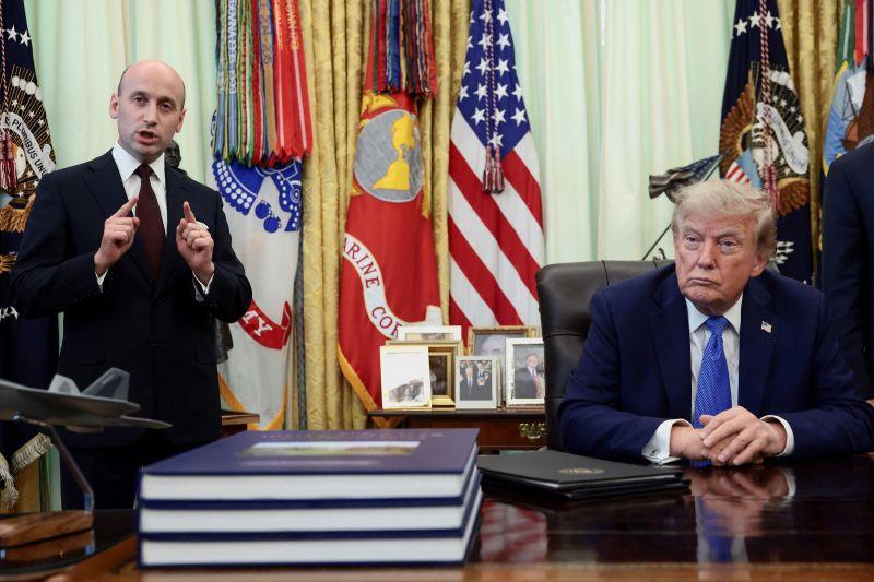 Phó Chánh Văn phòng Nhà Trắng Stephen Miller phát biểu trong khi Tổng thống Mỹ Donald Trump lắng nghe tại lễ ký các sắc lệnh hành pháp tại Nhà Trắng ngày 6-8. Ảnh: Reuters