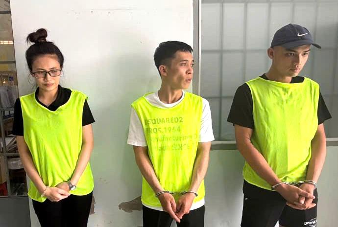 Từ trái qua, các đối tượng: Phạm Thị Cao Thiên, Nguyễn Huy Hoàng và Đỗ Cao Tiến và 3 chiếc ĐTDĐ tang vật vụ lừa đảo.
