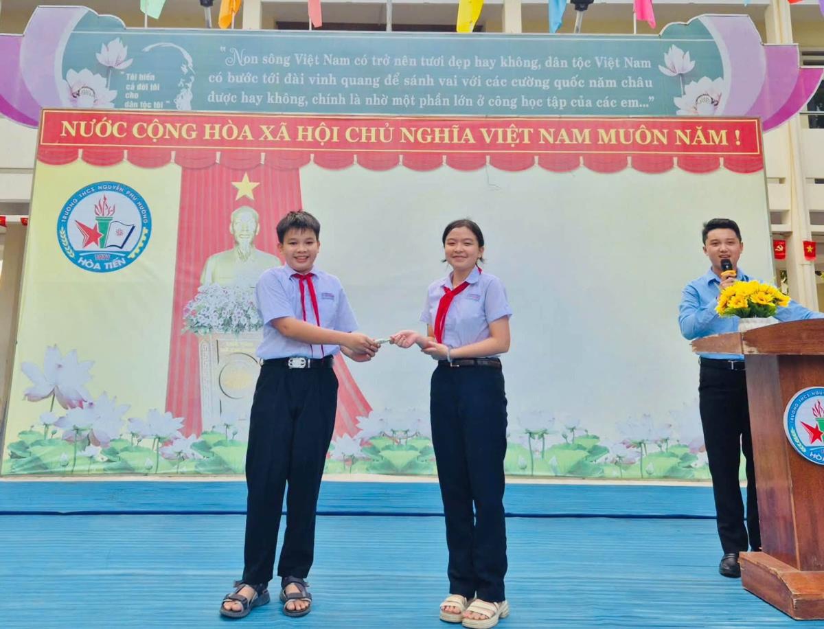 Em Minh trao trả tài sản nhặt được cho bạn.