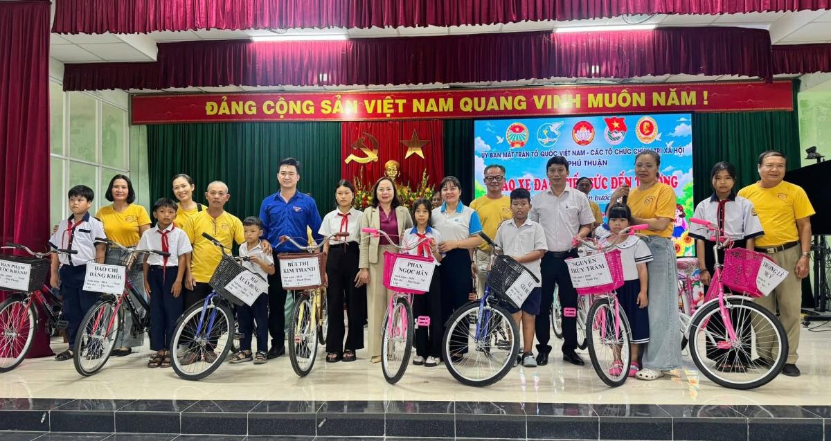 Đại diện chính quyền địa phương cùng các nhà hảo tâm trao tặng xe đạp cho các em học sinh có hoàn cảnh khó khăn.