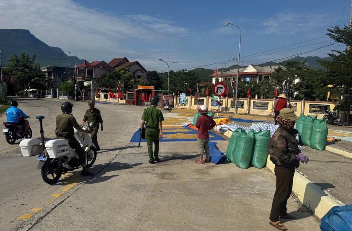 Công an xã Thượng Đức nhắc nhở người dân không lấn chiếm lòng đường để phơi lúa.