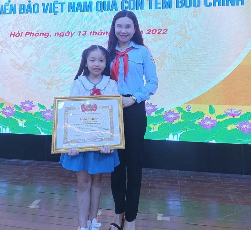 Thí sinh nhỏ tuổi nhất cuộc thi Trần Tuệ Mẫn nhận giải thưởng (ảnh trên) và chụp hình lưu niệm với GS Sử học Lê Văn Lan.