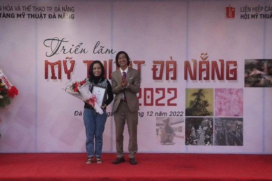 Chủ tịch Hội Mỹ thuật TP Đà Nẵng trao giải nhất cho họa sĩ Nguyễn Thị Đào với tác phẩm "Tuổi thơ". Ảnh: X.D