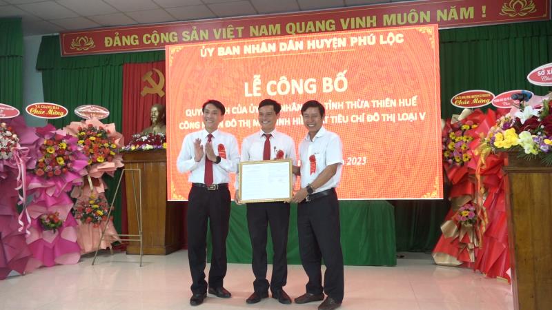 Ông Nguyễn Tam- Chủ tịch UBND xã nhận quyết định của UBND tỉnh về việc công nhận xã Vinh Hiền đạt tiêu chí đô thị loại V