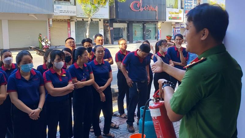 Lực lượng PCCC và CNCH Công an quận Thanh Khê hướng dẫn kỹ năng sử dụng bình chữa cháy xách tay.