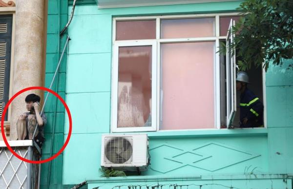 Nam thanh niên nghi ngáo đá ngồi vắt vẻo ở lan can tầng 2 ngôi nhà