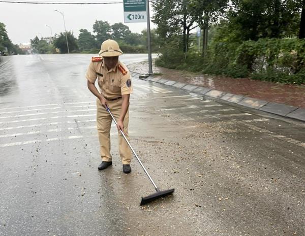 Hình ảnh đẹp CSGT thu dọn đất đá rơi vãi trên đường