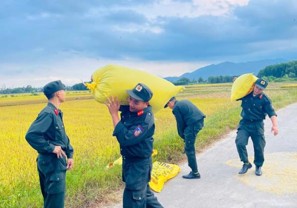 Cảnh sát cơ động Quảng Ngãi giúp dân gom lúa khi trời chuyển mưa