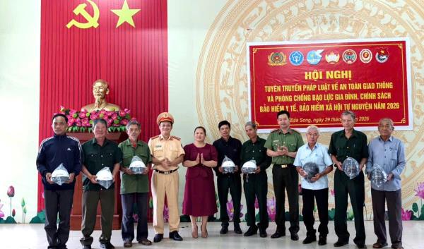 Công an xã Đắk Song tuyên truyền pháp luật và tặng mũ bảo hiểm cho người dân